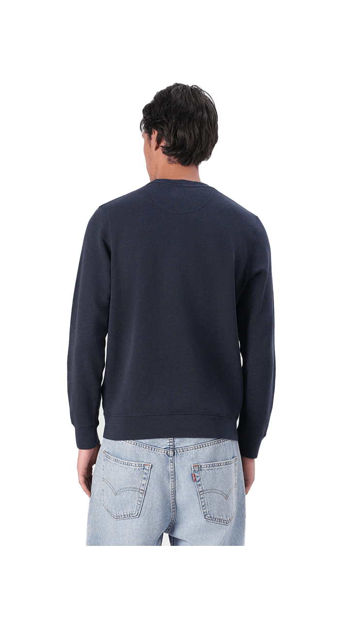 Rear view of a man wearing the Barbour Essential Prep Logo Crew sweatshirt in navy, paired with casual jeans.